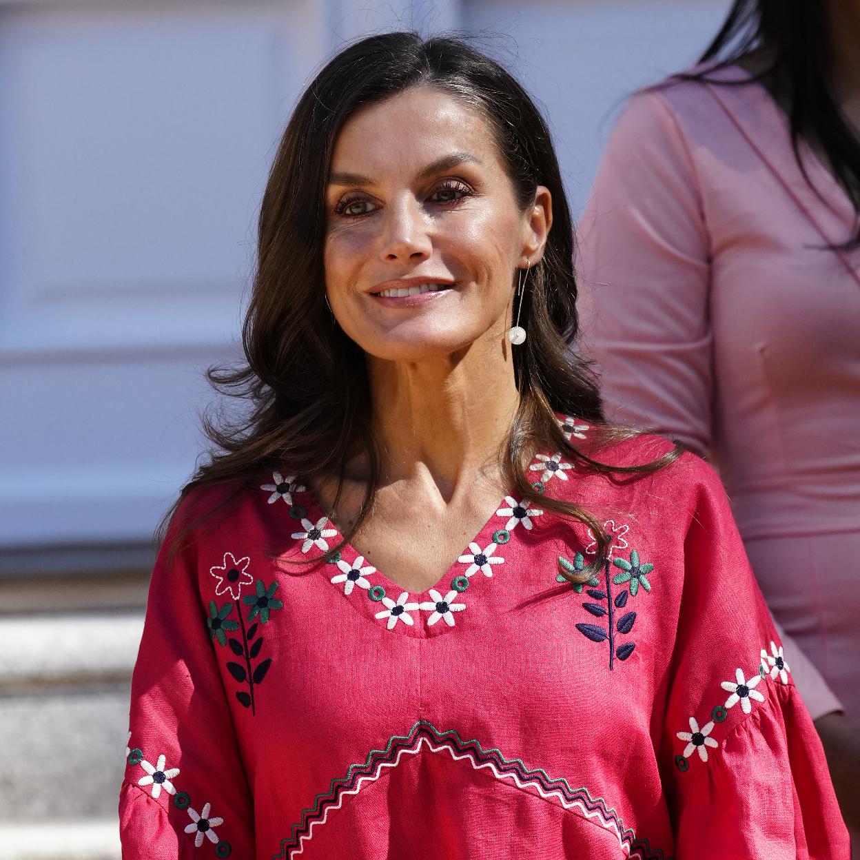 La reina Letizia con una blusa rosa.