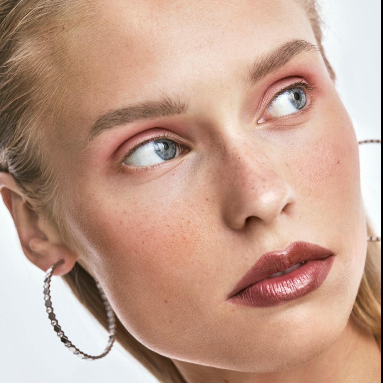 El lookn de maquillaje se consigue con diferentes tonos de rosa en labios, mejillas y párpados. Todo con productos de Shiseido. Los pendientes son de Cartier.