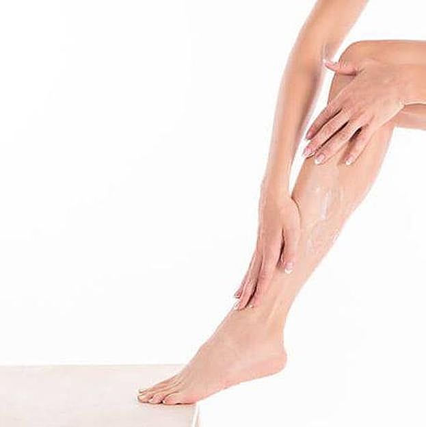 Mujer aplicando crema en las piernas