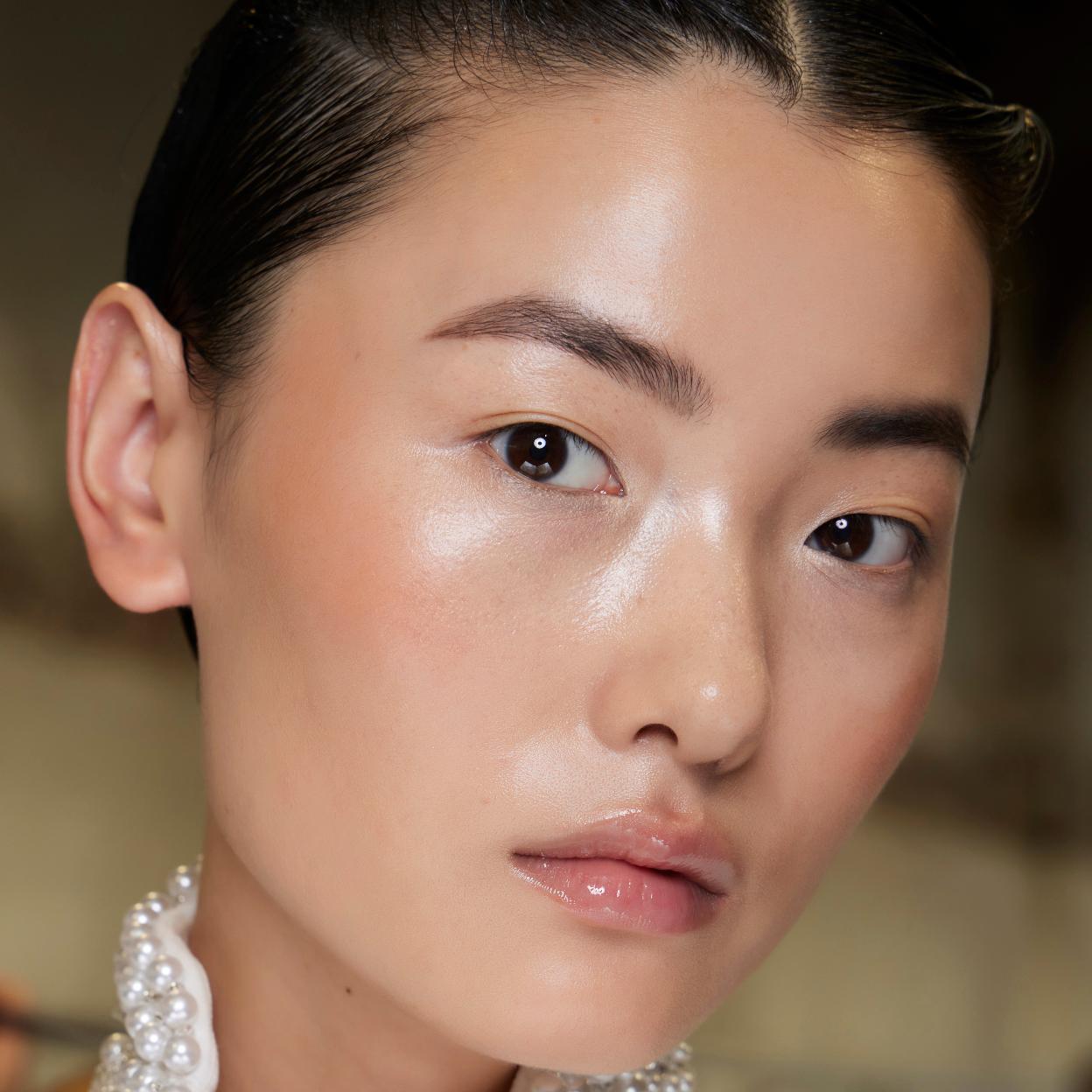 Una mujer con base de maquillaje glow.