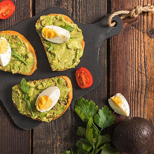 Tostadas con aguacate, huevo duro y rúcula. 