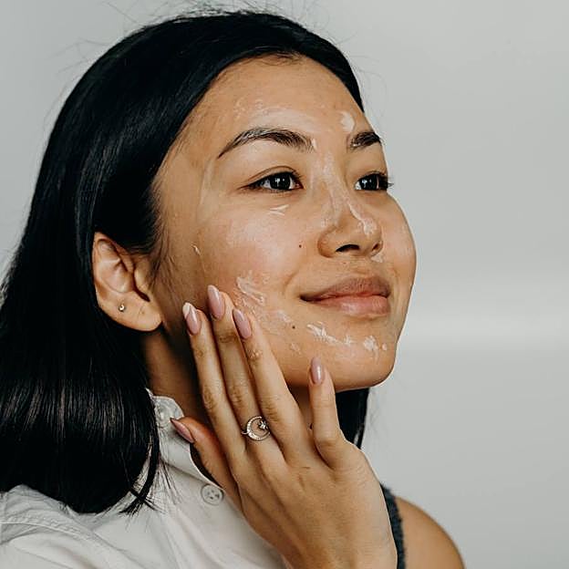 Mujer exfoliándose el rostro