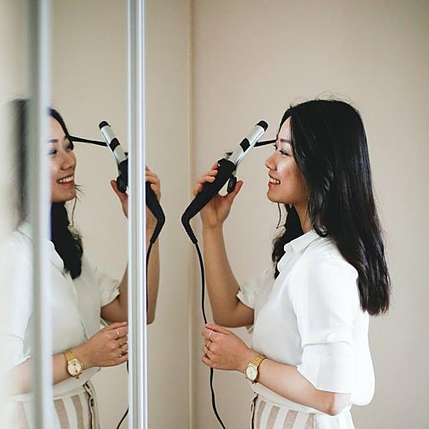Mujer usando rizador de pelo
