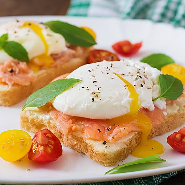 Tostadas con huevos escalfados, salmón y queso crema. 