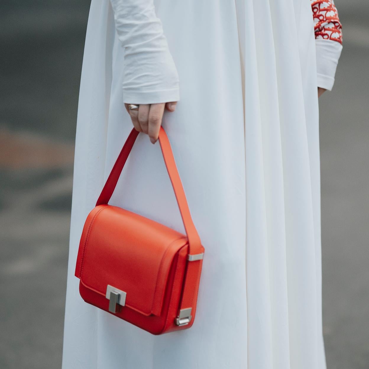 Una mujer con bolso rojo.