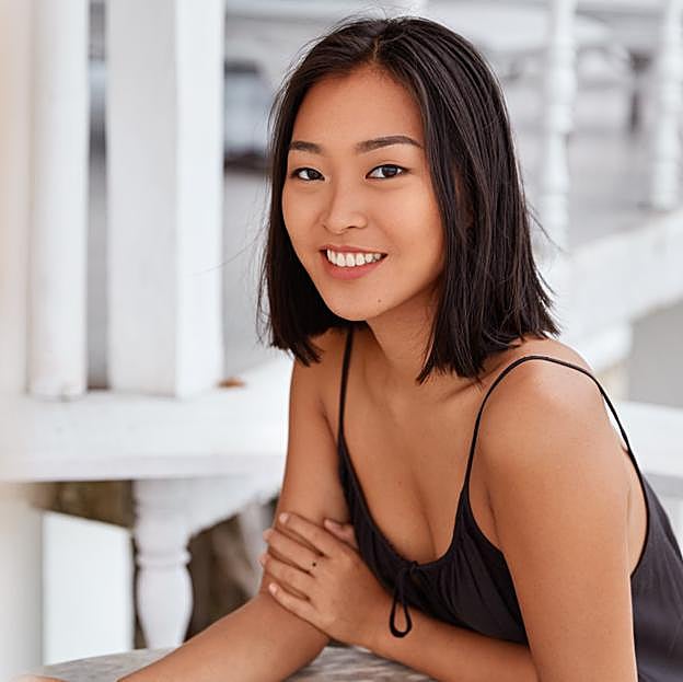 Mujer asiática sonriendo a la cámara. 