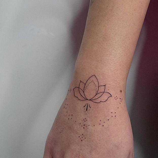 Tatuaje de flor de loto en la mano
