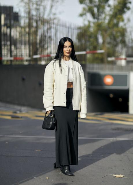 Imagen - Look formado por falda midi negra, bomber blanca y accesorios en negro.