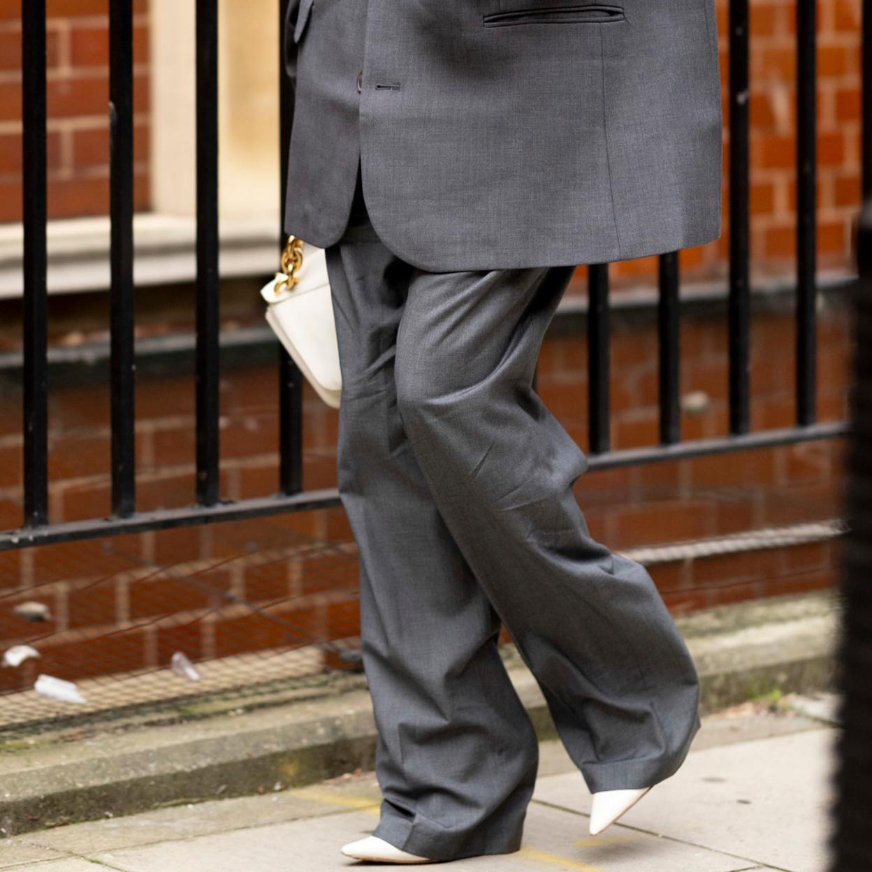 Una mujer con pantalones grises.