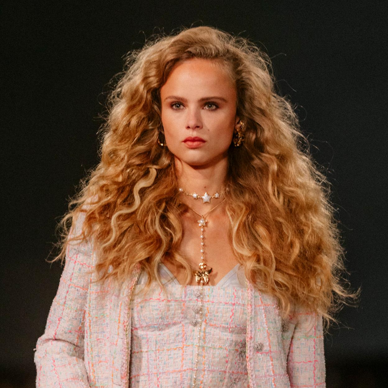 Una modelo con el cabello rizado.