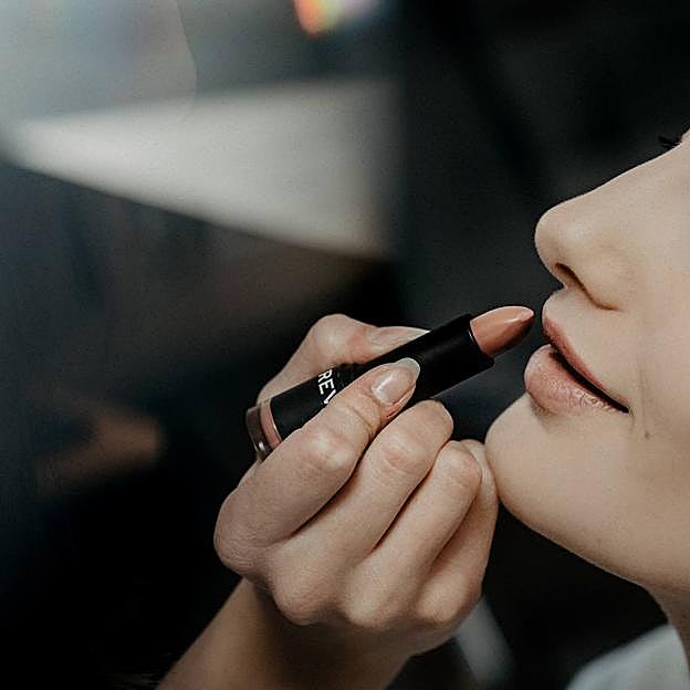 Maquilladora aplicando primer de labios