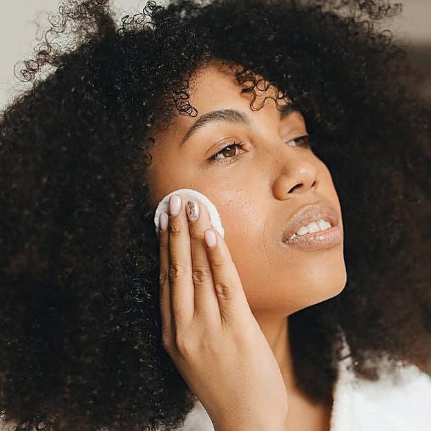 Mujer haciéndo limpieza facial con disco desmaquillante reutilizable
