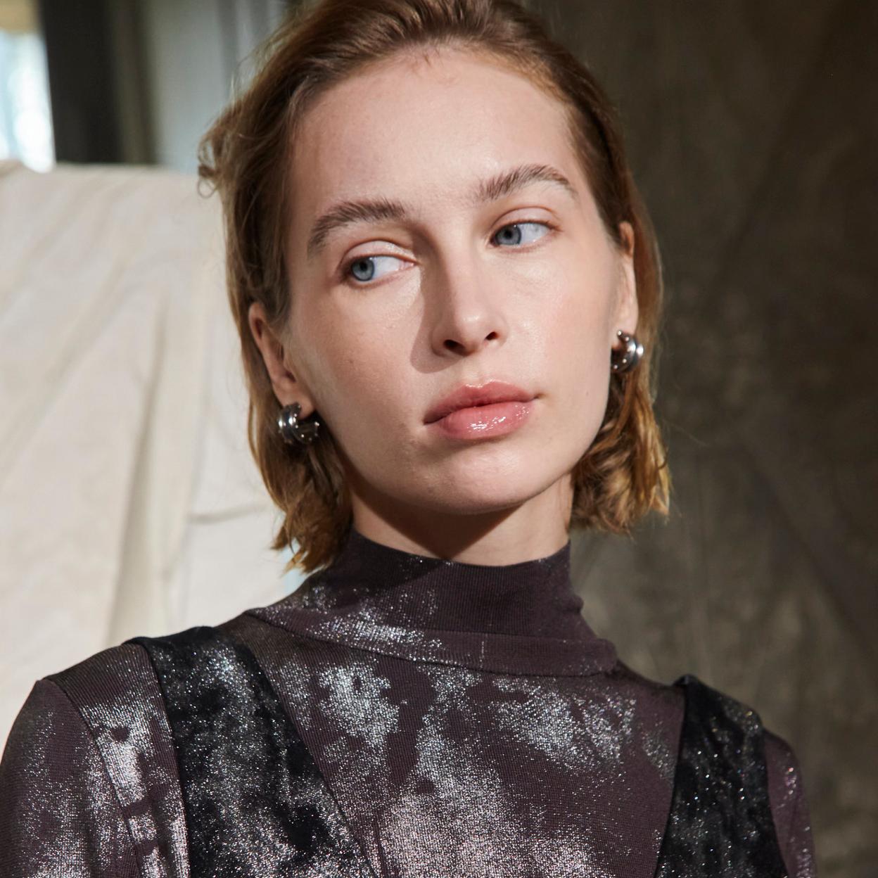 Una modelo con pendientes plateados.