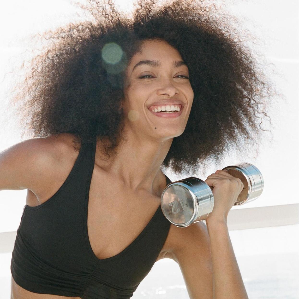 Mujer haciendo ejercicio con mancuernas. /