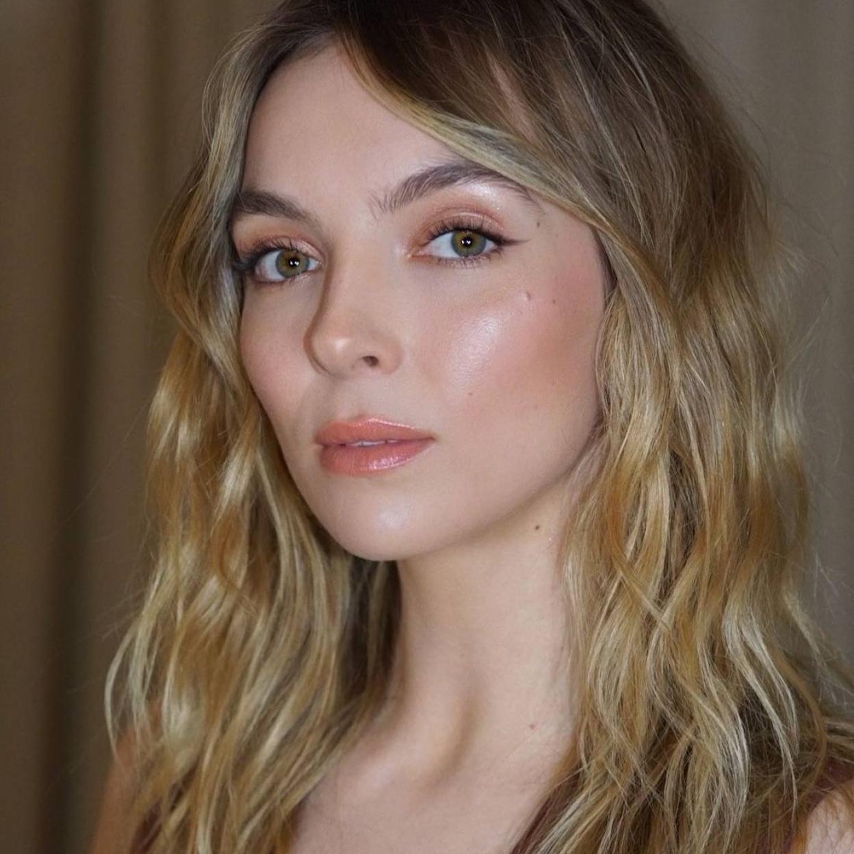 Jodie Comer con piel radiante con iluminador líquido