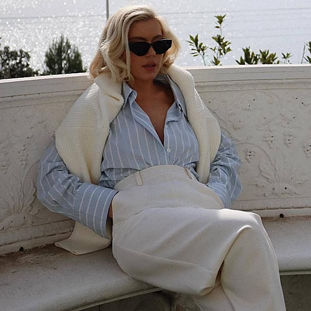 Look con pantalón de vestir blanco, camisa y jersey tipo lujo silencioso