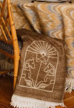 Imagen secundaria 2 - Conjunto de bata (140 euros) y camisón (95 euros), delantal falda de lino (85 euros); y manta con logo (65 euros). Todo de The IQ Home Collection. 