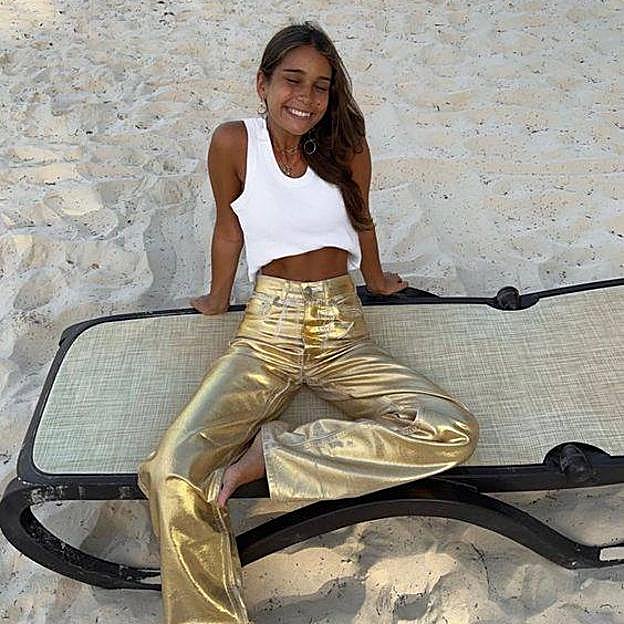 Influencer con pantalones de brillo dorados