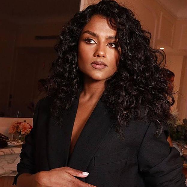 Simone Ashley con corte de pelo rizado a capas largas