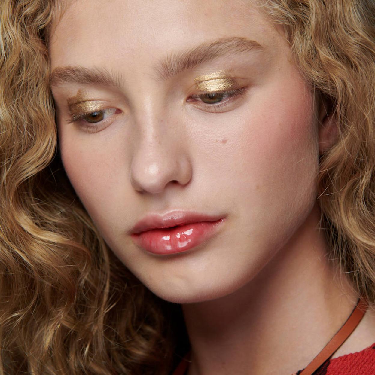 Modelo con labios brillantes pintados con lipgloss