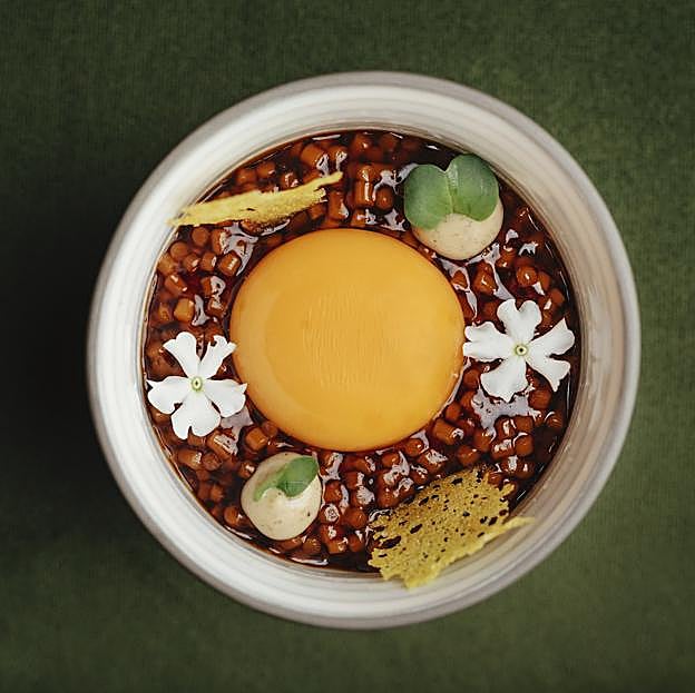 La yema de huevo de caserío sobre estofado de trigo de Eneko Basque Madrid, un plato que tienes que conocer este verano.
