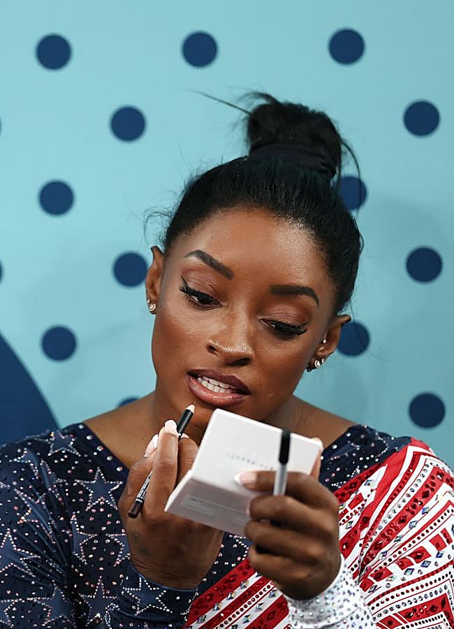 Imagen - Simone Biles retocándose el maquillaje con los polvos traslúcidos de Fenty Beauty y lápiz de labios de Nyx. Foto: Getty.