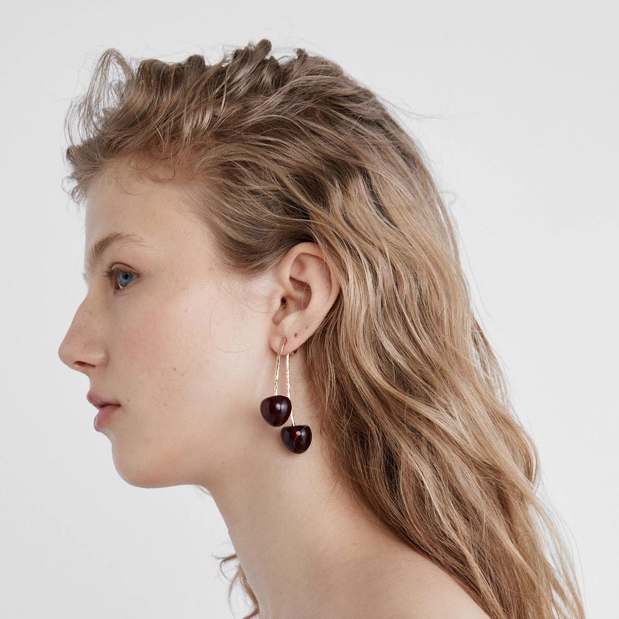 Una mujer con pendientes cereza.