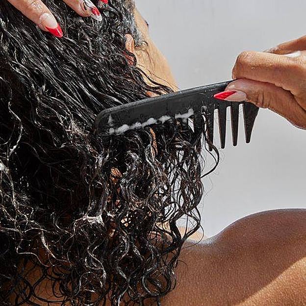 Mujer peinando pelo rizado