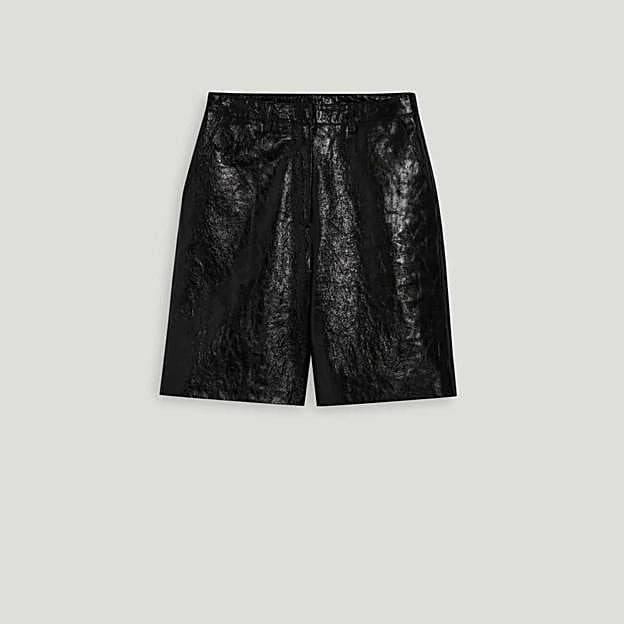 Imagen principal - Bermudas cuero negro de Claudie Pierlot (237€)/ Camisa blanca entallada algodón de Mango (22,99€)/ Mocasín piel detalle metálico de Mango (49,99€)