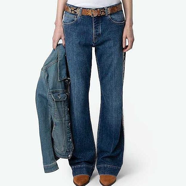 Imagen principal - Vaquero campana de mujer Vincente de tiro medio de Zadig & Voltaire (295€ en El Corte Inglés)/ Chaqueta 100% piel flecos de Mango (199,99€)/ Botas cowboy pespuntes de Pull&Bear (39,99€)