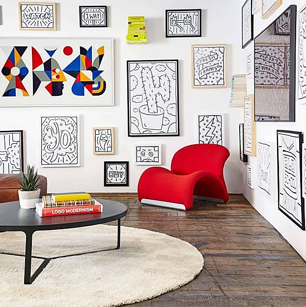 La interiorista Em Henderson apuesta por una original butaca en rojo y juega con uno de los cuadros.