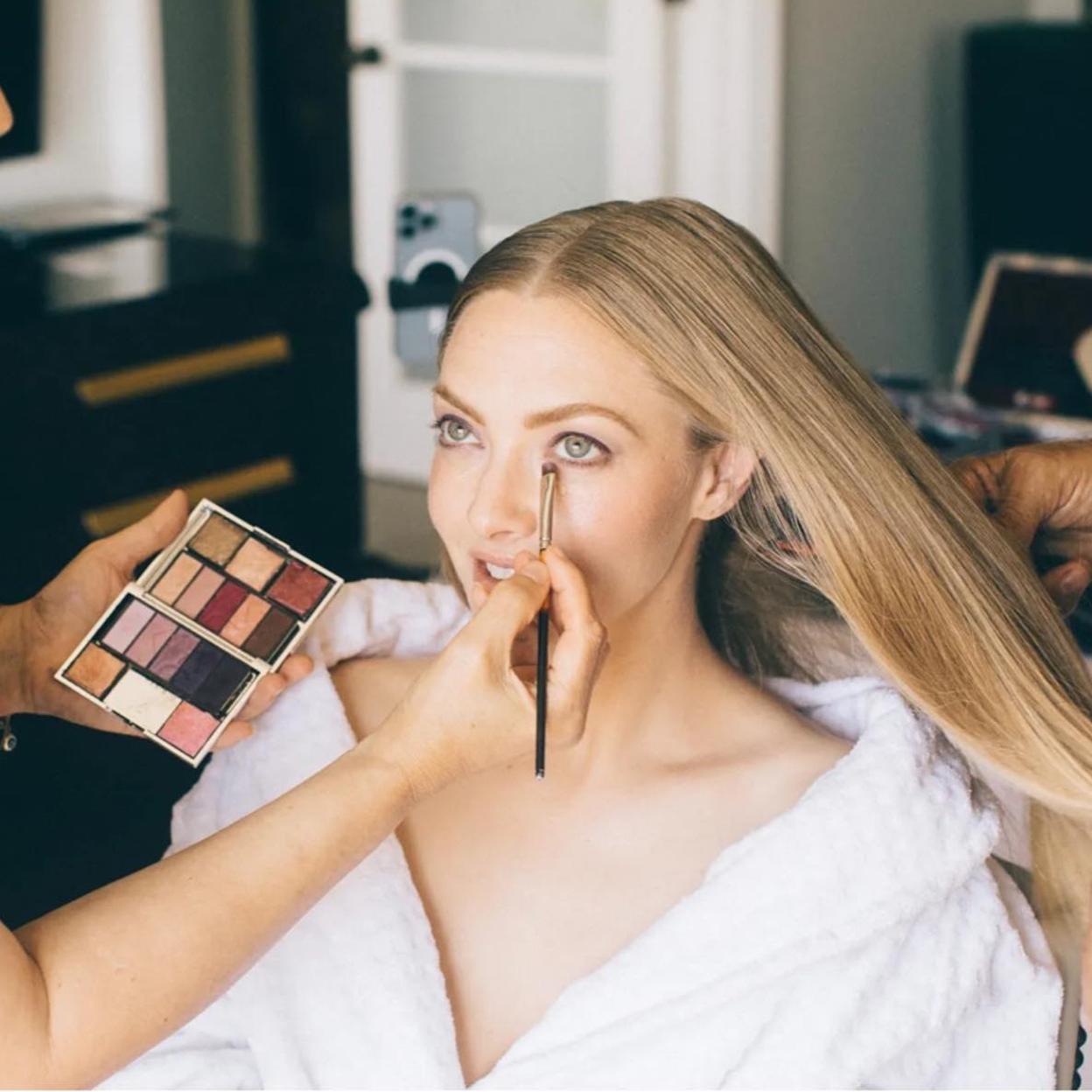 Amanda Seyfried maquillándose los ojos.