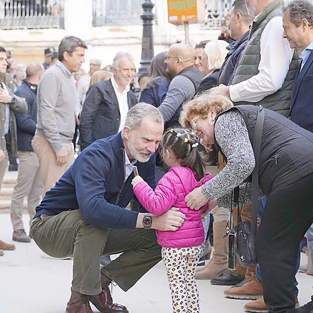 El rey Felipe charla con los vecinos de la Chiva durante su visita a la localidad valenciana. 