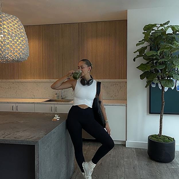 Mujer disfrutando de un smothie antes de ir a entrenar. 