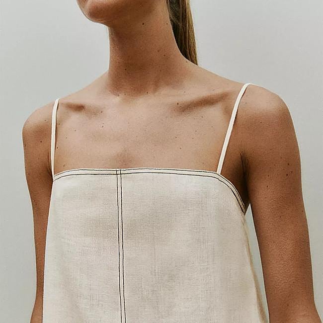 Top confeccionado en lino con pespunte en negro de Zara Home.