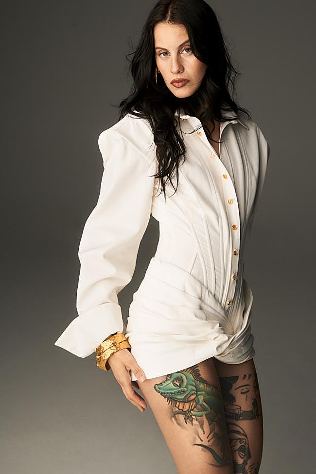 Milena Smit posa con un vestido drapeado, pendientes y brazaletes, todo de Schiaparelli.