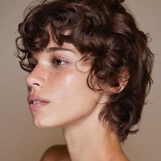 Modelo con corte de pelo bixie estilo garçon en pelo rizado