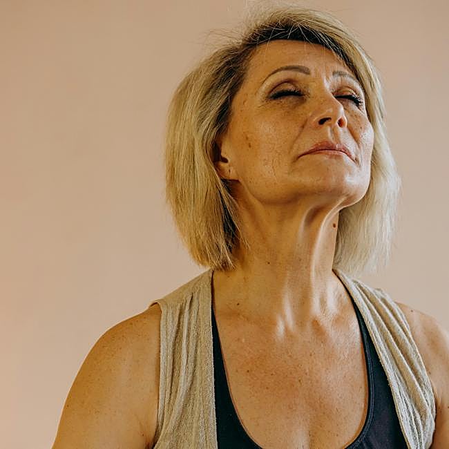 Mujer meditando en casa.