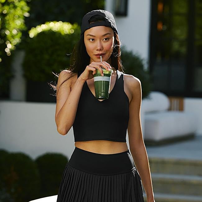 Mujer haciendo una pausa con un batido tras su entramiento.