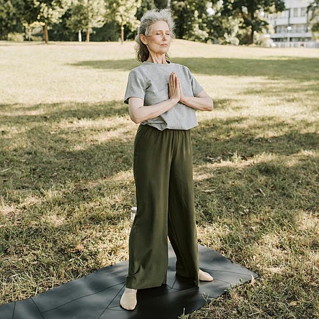 Mujer practicando yoga al aire libre.