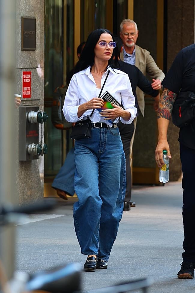 Katy Perry paseando con vaqueros y camisa blanca.