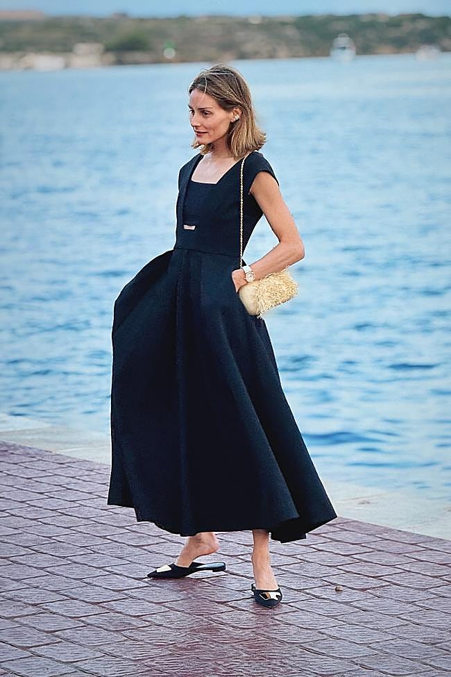 Olivia Palermo con un vestido negro y mules planos.