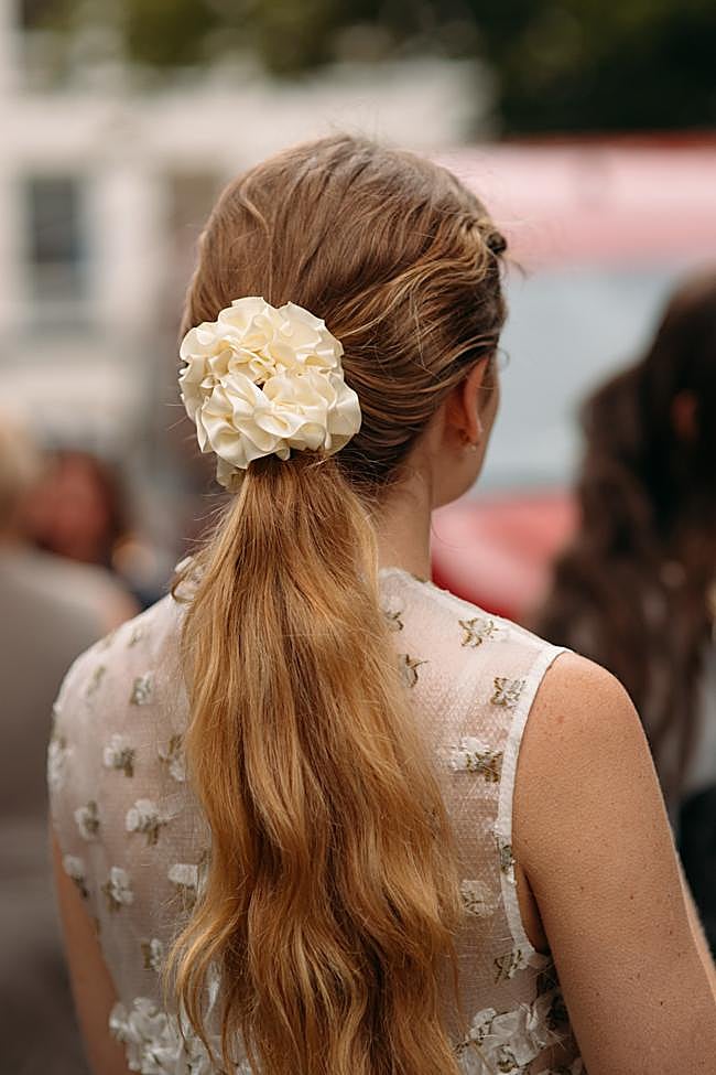 Una coleta ondulada con detalle de coletero floral.
