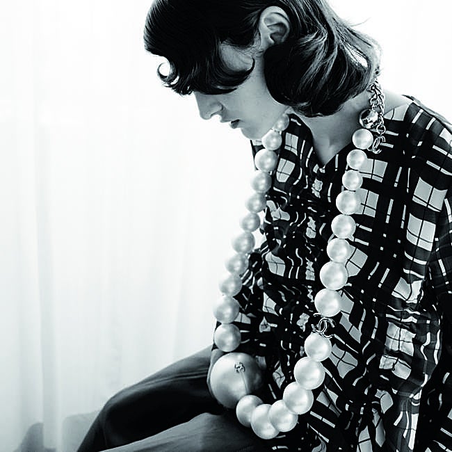 Blusa, de Stine Goya; falda de cuero, de Zimmermann, y bolso de perlas, de Chanel.