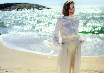 La directora Carla Simón en la playa de El Masnou, con blusa y pantalón de KM by LANGE, sandalias de ABOUT ARIANNE y pendientes de MÖULE..