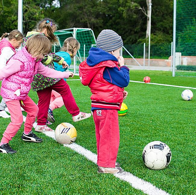 Niños y niñas practicando fútbol, una de las extraescolares más practicadas en nuestro país.