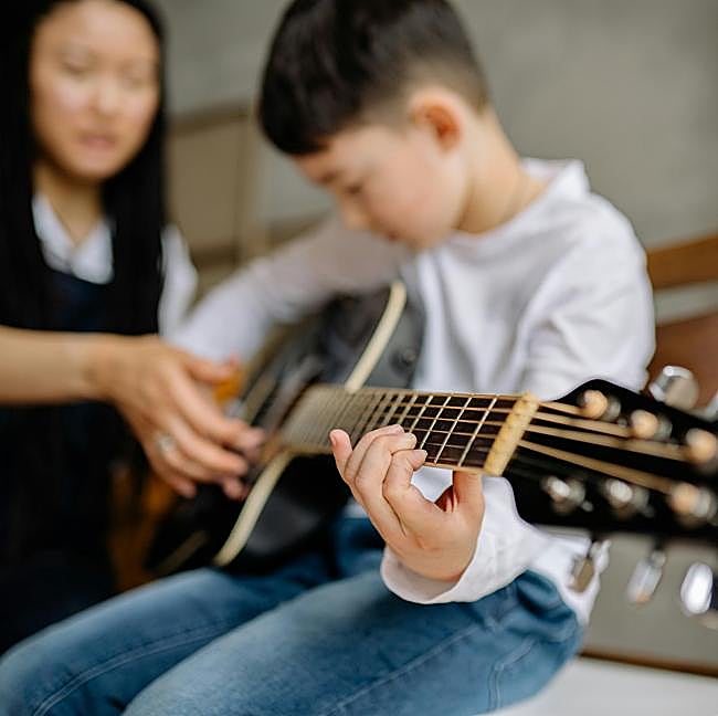 Las lecciones de guitarra son una actividad extraescolar en la preadolescencia, cuando el niño aprende a expresarse artísticamente.