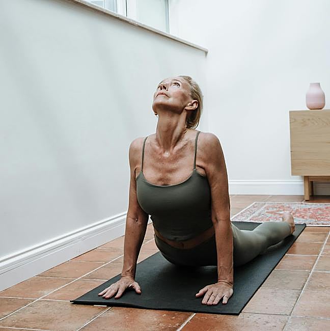 Mujer haciendo ejercicio sobre esterilla.