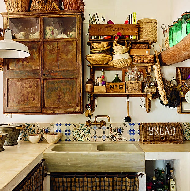 Imagen principal - Arriba, rincón de la cocina, con azulejos antiguos recuperados de Antic Alaior, lámpara en suspensión portuguesa, de Candelabro, y antigua pìla de piedra. A la derecha, detalle de la mesa con vajilla de insectos de Sena Cifuentes y vasos de vidrio pintados a mano de Agua Clara. A la izquierda, el perchero de la entrada con toda la impresionante colección de sombreros y cestas de madre e hija.