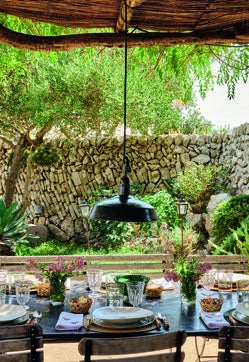 Imagen secundaria 2 - Arriba, dormitorio con cuadros bordados de Carina Casanovas y colección de figuras de cap i pota, de Antigüedades Pasquin. Abajo a la izquierda, comedor con sillas Bertoia y antiguas francesas de jardín, cuadro de Flora Castiglia, de Escat Gallery, y cerámica de Manises. A la derecha, vista del comedor exterior y del jardín.